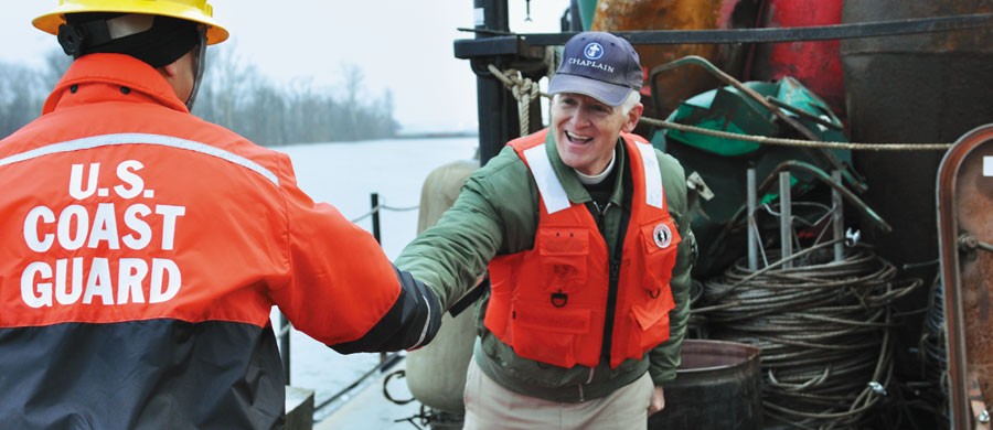Chaplain Kempton Baldridge of Seaman's Church Institute greets a crew member aboard the U.S. Coast Guard Cutter Chippewa. The Chippewa, a 75-foot buoy tender, is responsible for working floating and shoreline aids along the Tennessee, Ohio and upper Mississippi rivers. Baldridge travels these same rivers offering support and encouragement to members of the inland merchant marine. Photo courtesy of Gregory Thorp.