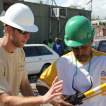 Shelby Electric Lineman Brian Chevalier explains how to use a hotstick to a Haitian lineman.