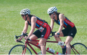 Lindsey Cook pilots the tandem bike during the second leg of the triathlon