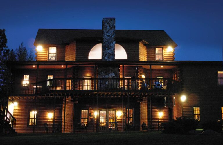 Heartland Lodge with brightly lit windows under a night sky.