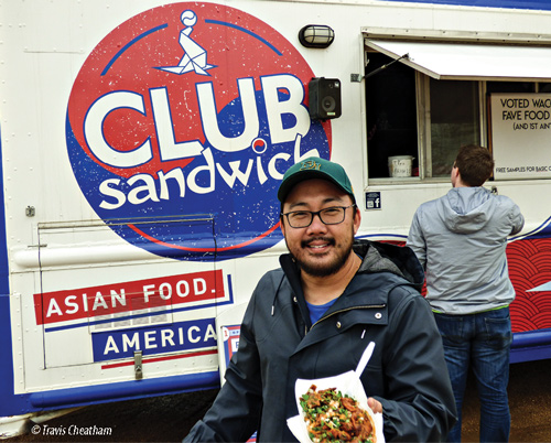 Man holding meal outside of Club Sandwich Korean American food truck.