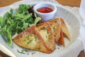 Goonies - wontons filled with lobster, cream cheese and green onions, served with a sweet Thai chili sauce