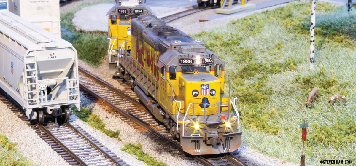 A yellow and grey model Union Pacific train on tracks.