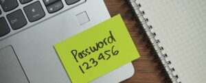 Sticky note with the word "password 123456" on a laptop keyboard