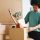 Young Asian man putting stuff into carton box preparing moving t