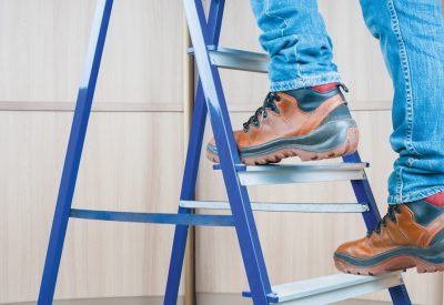 Handyman climbing on steel ladder indoor