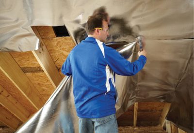 Man installing reflective foil insulation