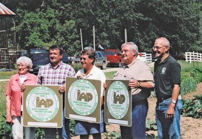 Grandmother Rita along with sons (l-r) Richard, Robert and Steven hold the new Sesquicentennial Farm signs presented to them by State Rep. Jim Sacia.