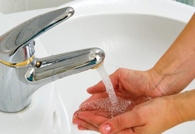 Washing hands in bathroom sink